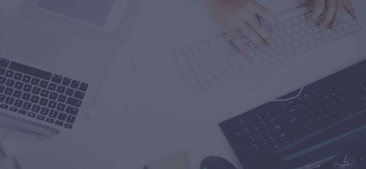Hands typing on multiple keyboards and laptops.