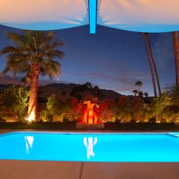 Evening poolside view with vibrant lighting.